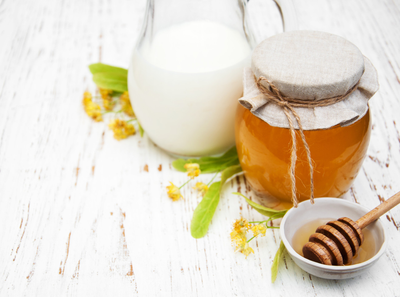 Linden honey and milk on a old wooden background